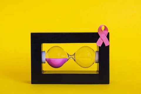 Creative visual of a horizontal hourglass left side is filled with pink san.. Stock Photos