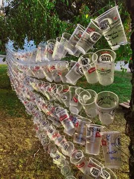 Creative wall made from plastic beer cups, trees background Stock Photos