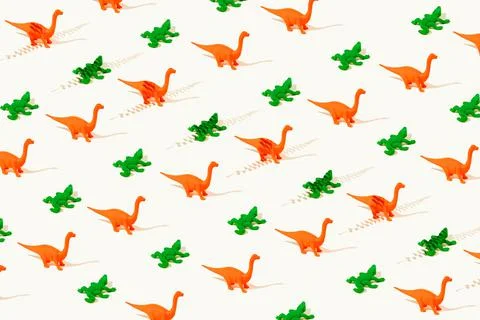 Creative wallpaper seamless pattern of rubber orange dinosaurs and green Stock Photos