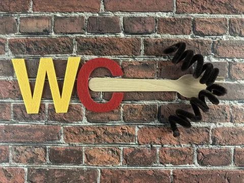 Creative WC Typography Installation on Rustic Brick Wall Stock Photos