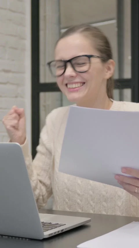 Creative Woman Celebrating while Using Laptop and Documents, vertical video Stock Footage 325831809