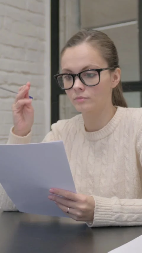 Creative Woman Feeling Upset while Reading Contract at Work, vertical video Stock Footage 325832339