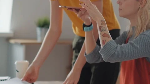 Creative woman with tattoos makes a flat lay, takes pictures on phone Stock Footage 104101695