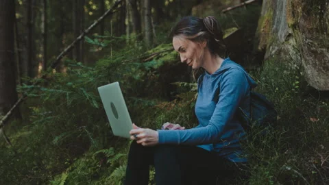 Creative woman types on laptop computer in forest Stock Footage 266745481