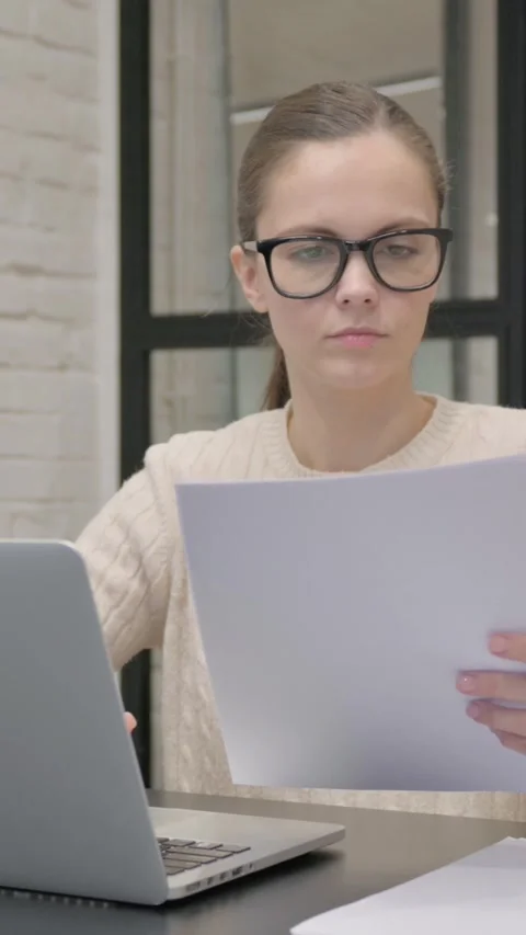 Creative Woman Working on Documents and Laptop, vertical video Vidéo 325831739