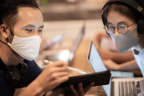 Creative worker team wearing face mask, working at business co-working space Stock Photos
