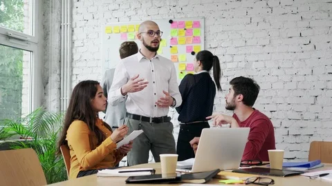 Creative workers disussing ideas and brainstorming in modern office space Stock Footage 94577396