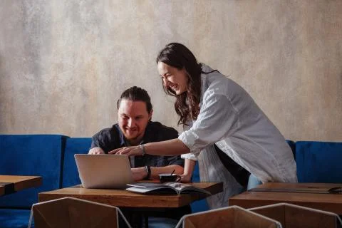 Creative workers. Young colleagues a guy and a girl discuss some information  Stock Photos
