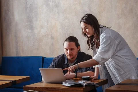Creative workers. Young colleagues a guy and a girl discuss some information  Stock Photos
