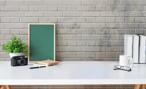 Creative workplace with green chalkboard, camera, coffee cup and books on whi Stock Photos