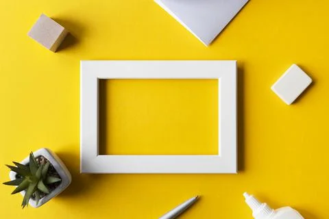 Creative workplace or workspace with bright yellow surface, blank photo frame Stock Photos