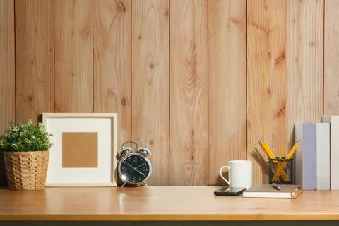 Creative workplace with picture frame, clock and plant on white table again.. Stock Photos