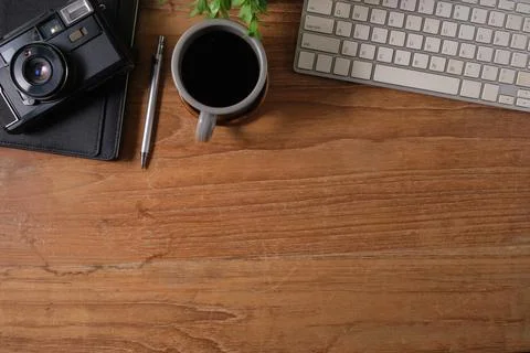 Creative workplace with retro camera, coffee and notebook on wooden table. .. Stock Photos