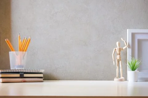 Creative workspace with blank poster frame, coffee cup, books and flower po.. Stock Photos