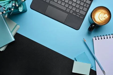Creative workspace with computer tablet, coffee cup and notebook on blue Stock Photos