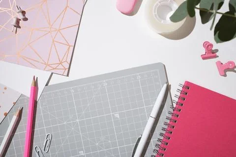 Creative workspace with cutting mat, pink notebook, pencils, pen and statio.. Stock Photos
