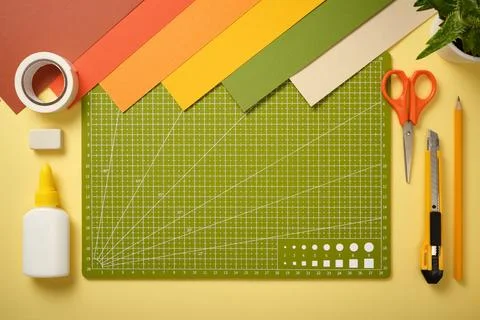 Creative workspace with cutting mat, scissors, knife, pencil, glue, tape an.. Stock Photos