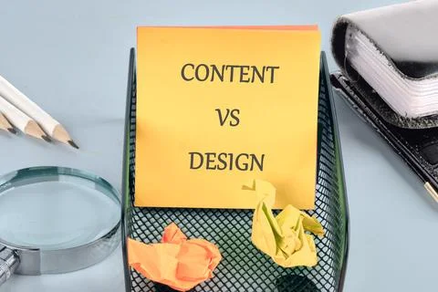 A creative workspace features a vibrant notepad reading content vs design. Cr Stock Photos