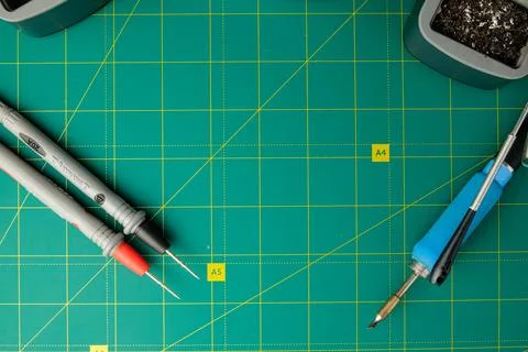 Creative workspace filled with tools for crafting on a vibrant green mat Stock Photos
