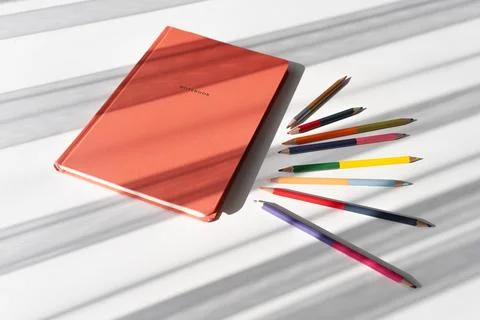 Creative Workspace with Notebook and Colorful Pencils in Natural Light Foto stock
