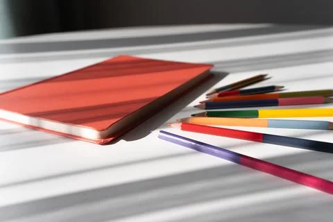 Creative Workspace with Notebook and Colorful Pencils in Natural Light Foto stock