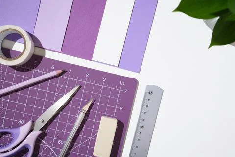 Creative workspace with purple hobby tools, paper, and cutting mat on white.. Stock Photos