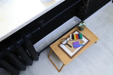 Creative workspace setup with art supplies and magnifying glass on a tray Stock Photos