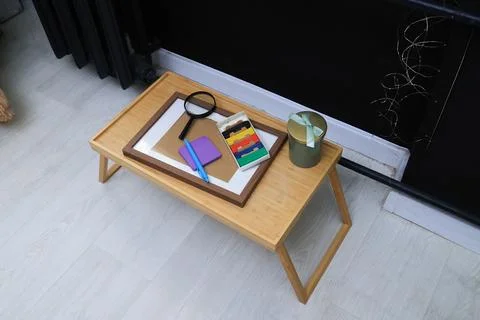 Creative workspace setup with art supplies and magnifying glass on a wooden.. Stock Photos