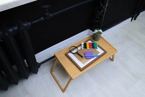 Creative workspace setup with art supplies and magnifying glass on a tray Stock Photos