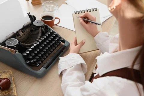 Creative writer brainstorming ideas with notebook and pen next to vintage typ Stock Photos