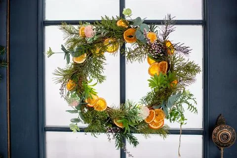 Creative xmas wreath of pine branches, cones and citrus. Stock Photos