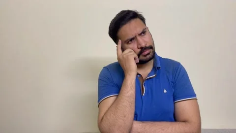 Creative young handsome model rubbing chin and beard, thinking and having idea Stock Footage 241446349