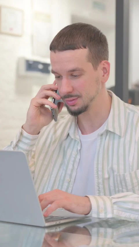 Creative Young Man Talking on Phone at Work, vertical video Video stock 325563937