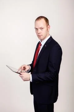 Creative young programmer in a business suit with a tie and sunglasses presents 写真素材