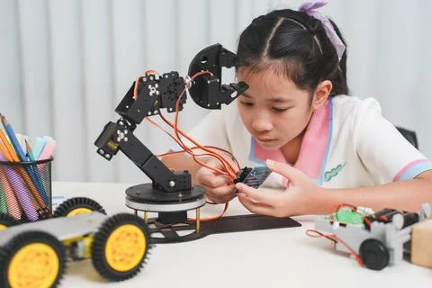 Creative young student focused on her DIY electronic robot, representing the Stock Photos