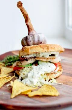 Creatively styled beef burger rustic home made chips or crisps Garlic on top Foto stock