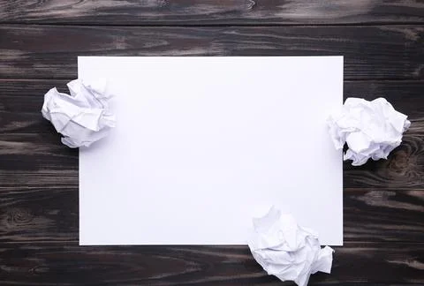 Creativity concept, crumpled paper and blank sheet on brown wooden background Stock Photos