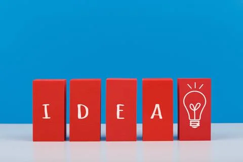 Creativity concept. Idea written on red toy blocks and drawn light bulb against Stock Photos