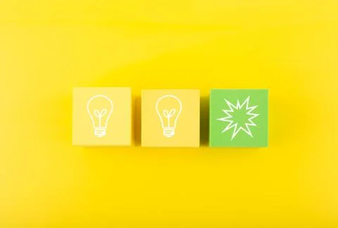 Creativity concept. Light bulbs on yellow and green toy blocks against bright Foto stock