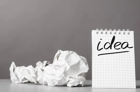 Creativity creative process. crumpled wads and notebook with word idea Cop... 库存照片
