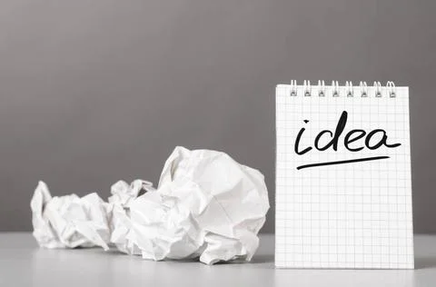 Creativity creative process. crumpled wads and notebook with word idea Cop... Stock Photos