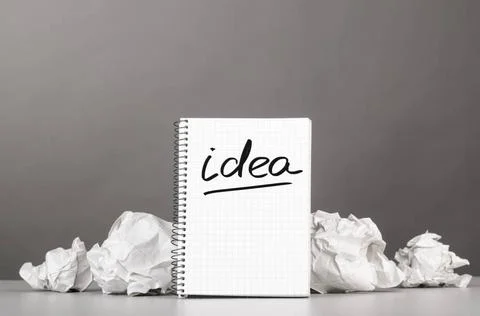 Creativity creative process. crumpled wads and notebook with word idea Cop... Stockfoto's