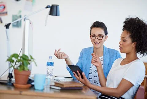 The creativity is flowing. two coworkers using a digital tablet together in the Stock Photos