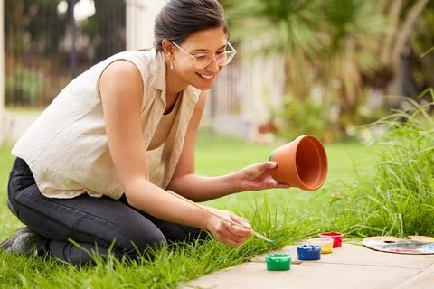 Creativity is just connecting things. s young woman painting a pot in the garden Fotos Stock