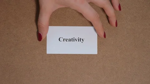 CREATIVITY. Top shot - Hand puts paper card with word. CORE VALUE concept. Vídeo Stock 124887432