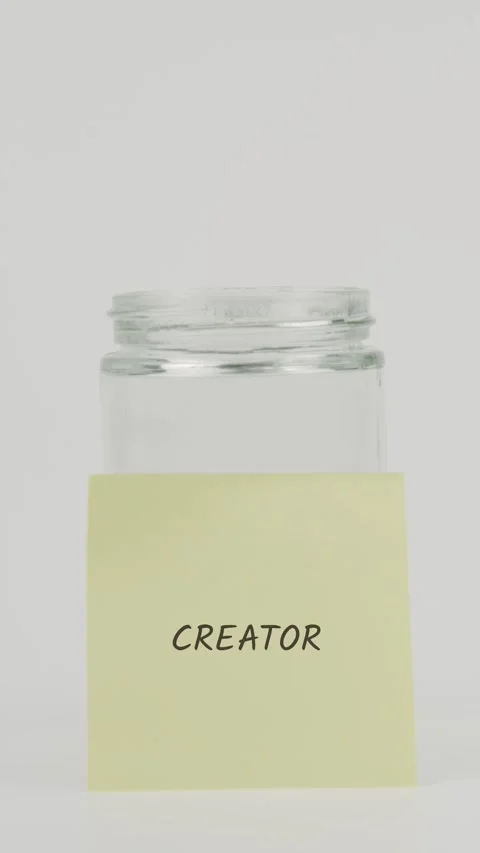 Creator text or word on yellow sticky note attached to glass jar with hand Stock Footage 311701973