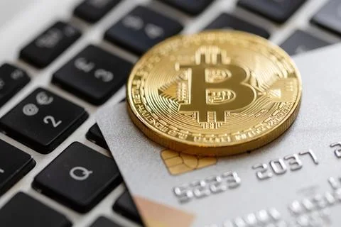 Credit card and bitcoin on the computer keyboard Stock Photos