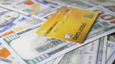 Credit card with dollar bills rotating on a table Stock Footage 160549341