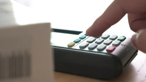 A credit card reader sits on a table next to a white box Stock Footage 313350872