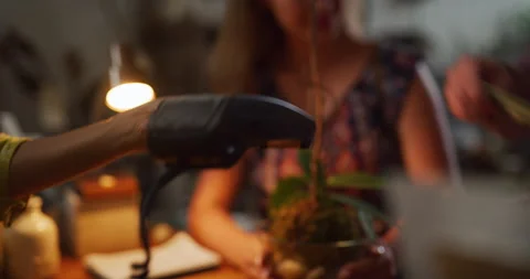 Credit card tap function used to buy orchid in interior boutique plant shop with Stock Footage 199457817